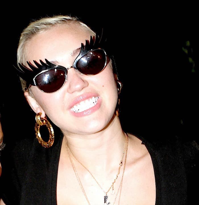 Miley Cyrus accessorizes her casual ensemble with stylish sunglasses and vintage earrings from Chanel curated by Rad and Refined