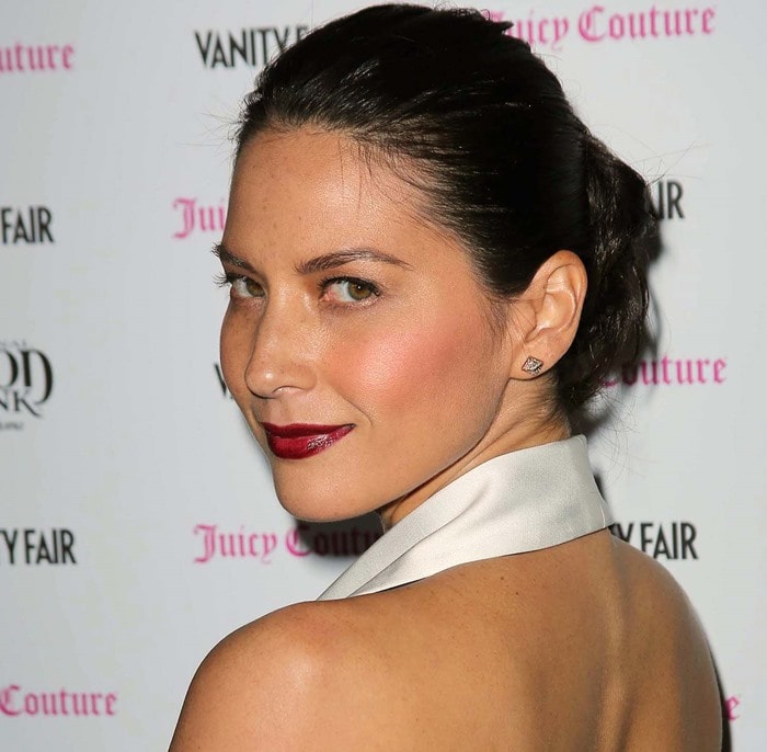 Olivia Munn rounded off her outfit with a touch of gothic elegance, featuring sleek, slicked-back hair and a striking vermillion lip