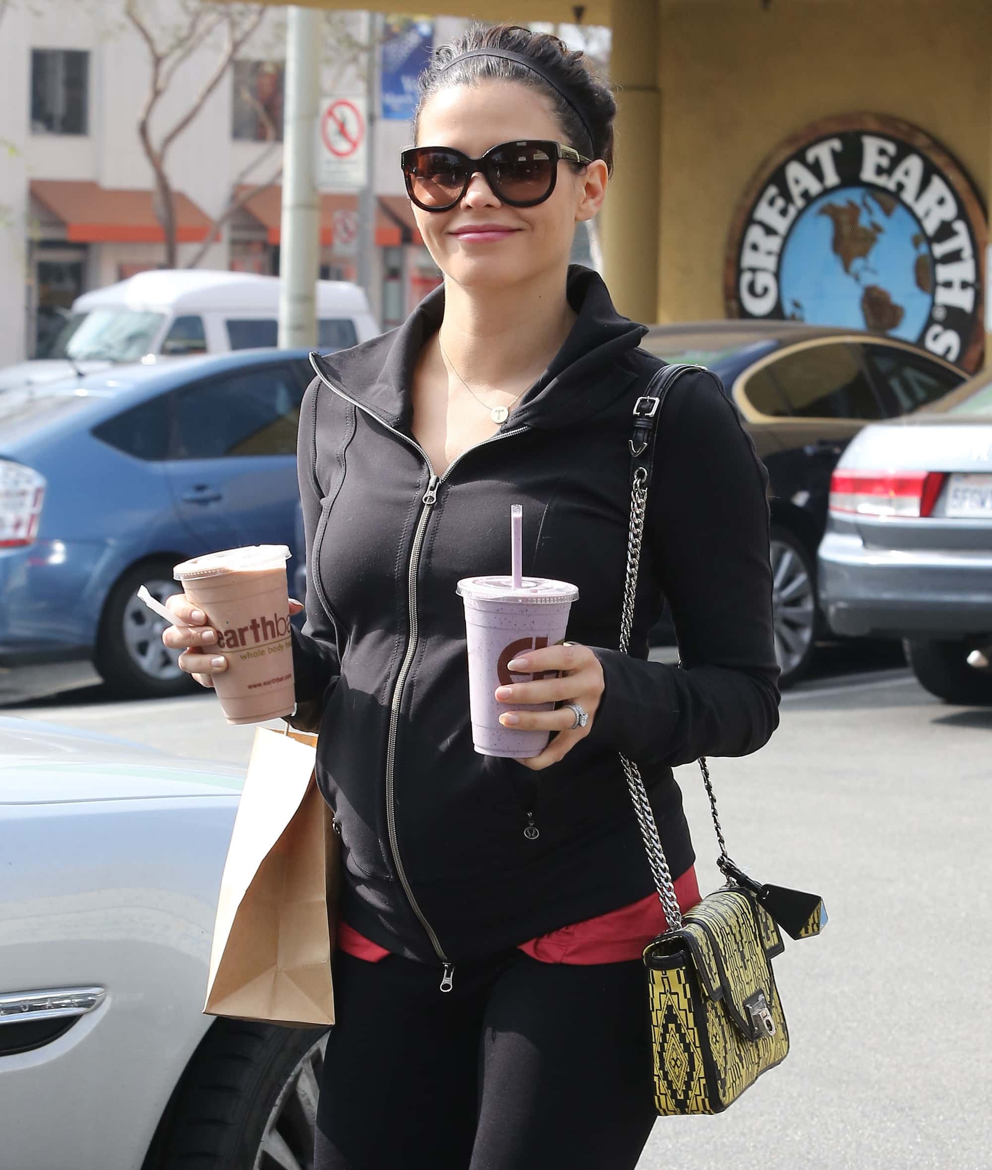 Jenna Dewan Tatum exudes casual chic in a black zip-up jacket, leggings, and her bold patterned Rebecca Minkoff Alaina handbag, completing the look with oversized sunglasses and a pop of pink from her underlayer