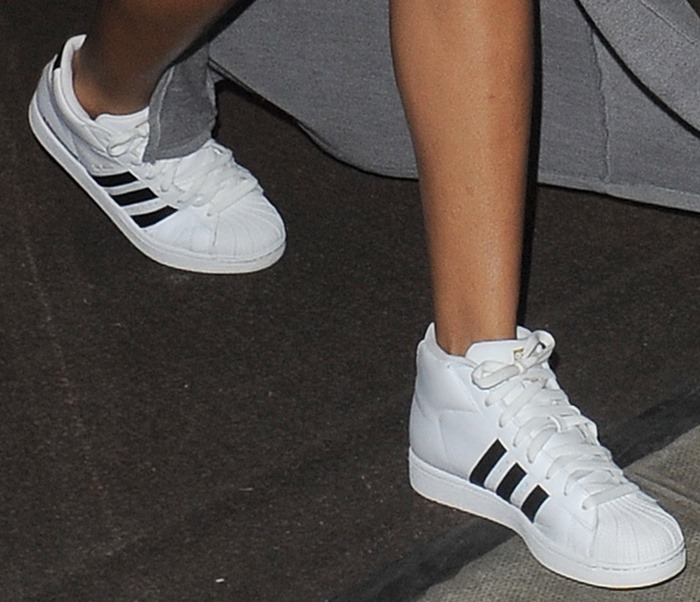 Rihanna stepped out in crisp white adidas Pro Model sneakers, featuring the brand’s iconic shell toe and three black stripes, adding a sporty edge to her thigh-slit maxi skirt look