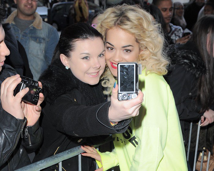 Rita Ora poses for photos with fans outside of the BBC Radio 1 studios in London
