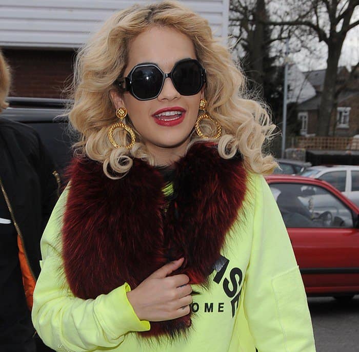 Signature Style: Rita Ora complements her curled ringlets with a vibrant red scarf