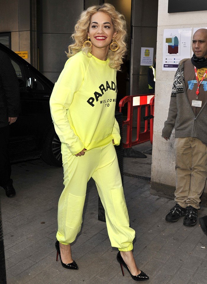 Rita Ora rocks a bright yellow "Paradise"-emblazoned sweatsuit while out for media appearances in London
