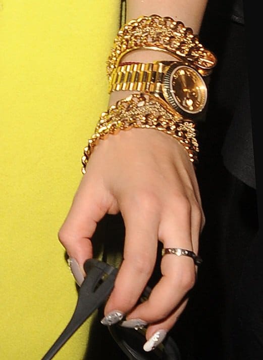 Rita Ora showcases her flair for bold accessories with chunky gold bracelets and a statement watch