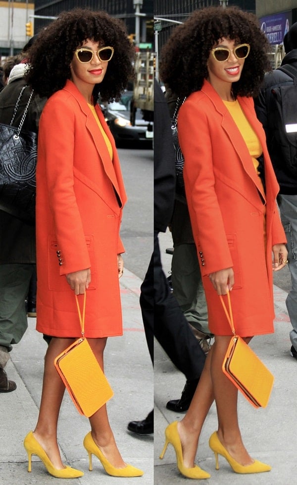 Solange Knowles makes a stunning entrance at the Ed Sullivan Theatre, showcasing her flair for fashion in a bright orange Proenza Schouler coat and a vibrant yellow dress, perfectly accented with matching Sergio Rossi pumps