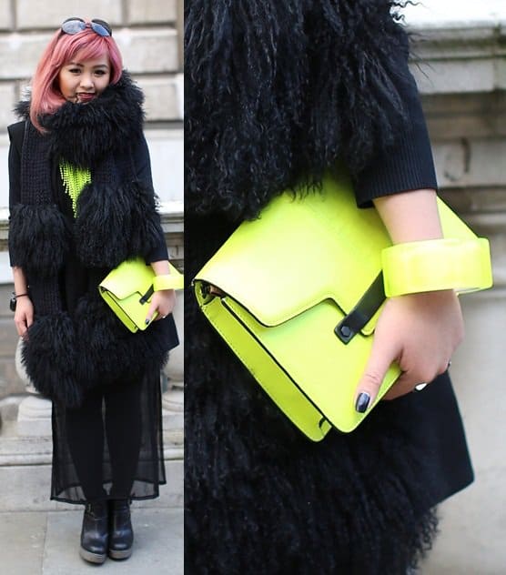 Making a bold statement, this neon yellow clutch adds a vibrant pop to an all-black textured outfit, perfectly reflecting edgy street style