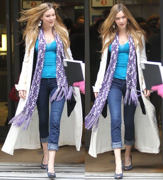 oss Stone pairs classic jeans with elegance, draping a long coat over her shoulders and accentuating her look with a chic purple and white crocheted scarf, capturing a blend of casual sophistication as she steps out of the BBC Radio Two Studios