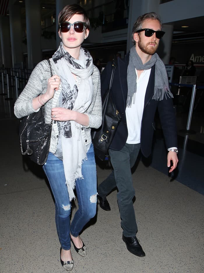 Both wearing scarves, Anne Hathaway and Adam Shulman make their way through LAX airport