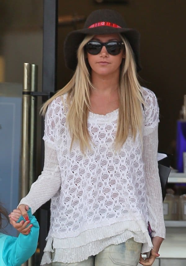 Ashley Tisdale wears patched utility skinny jeans and a wide-brimmed hat