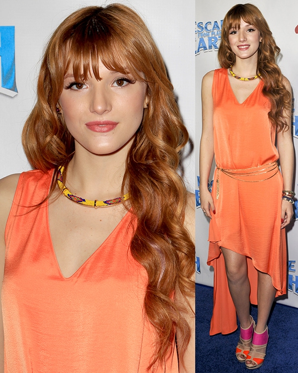 Bella Thorne brightens up the red carpet in an orange asymmetrical dress paired with colorful heels and a bold necklace at the Escape from Planet Earth premiere