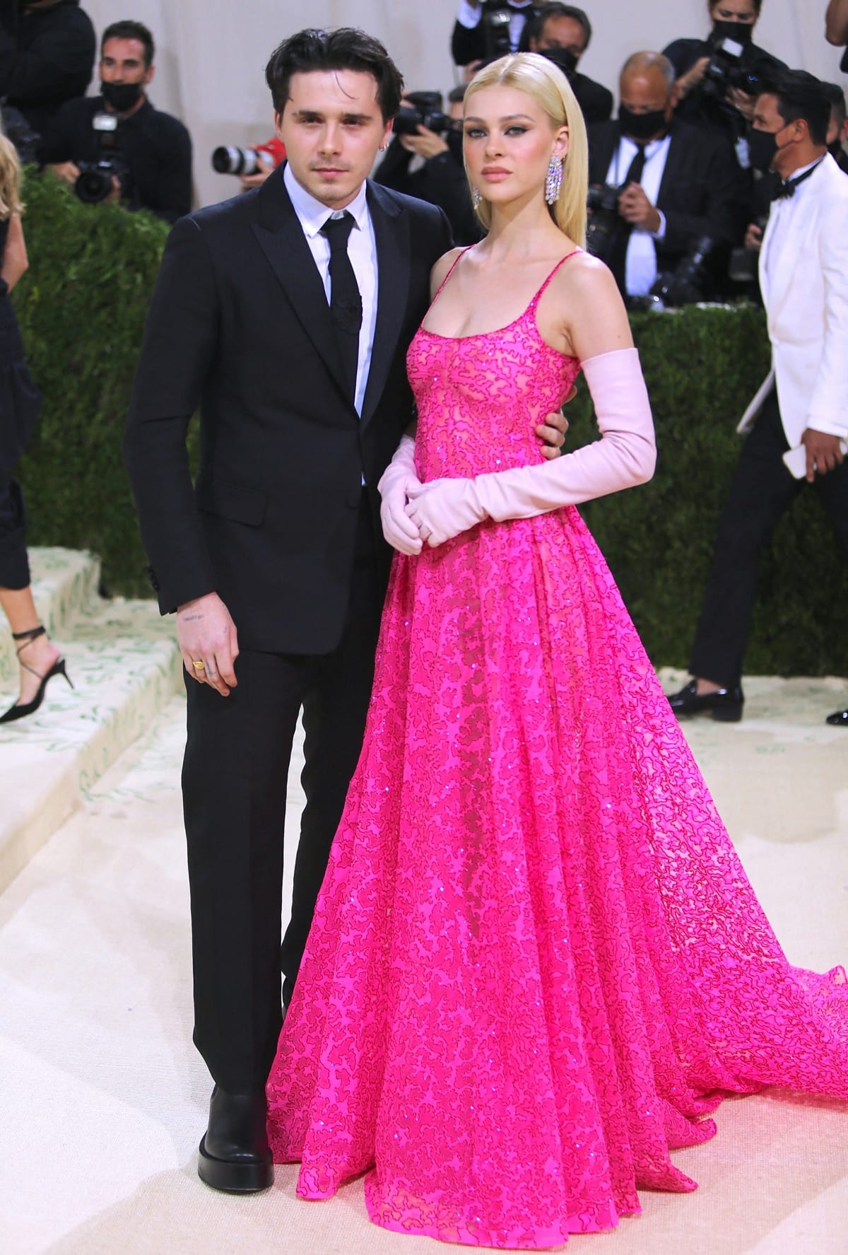 Brooklyn Beckham in a black Valentino suit and Nicola Peltz in a sparkling pink Valentino gown at the 2021 Met Gala benefit "In America: A Lexicon of Fashion" at Metropolitan Museum of Art