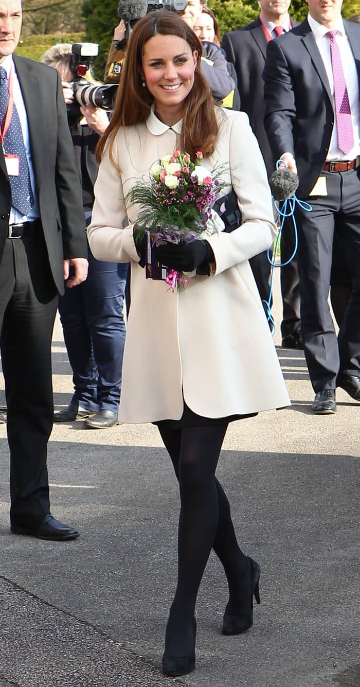 Underneath the coat, Kate Middleton wore a black short-sleeved shift dress from Topshop, distinguished by a contrasting white collar