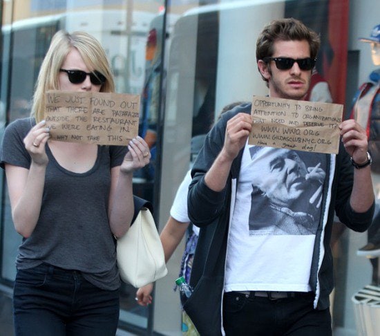 Emma Stone and Andrew Garfield leaving a restaurant after having lunch together, holding handwritten signs promoting organizations they believe in New York City on September 15, 2012