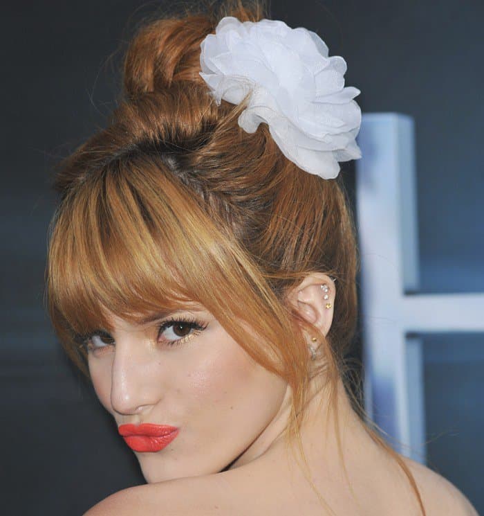 Bella Thorne with minimal jewelry but wearing an oversized flower clip on her hair at the premiere of 'The Host'