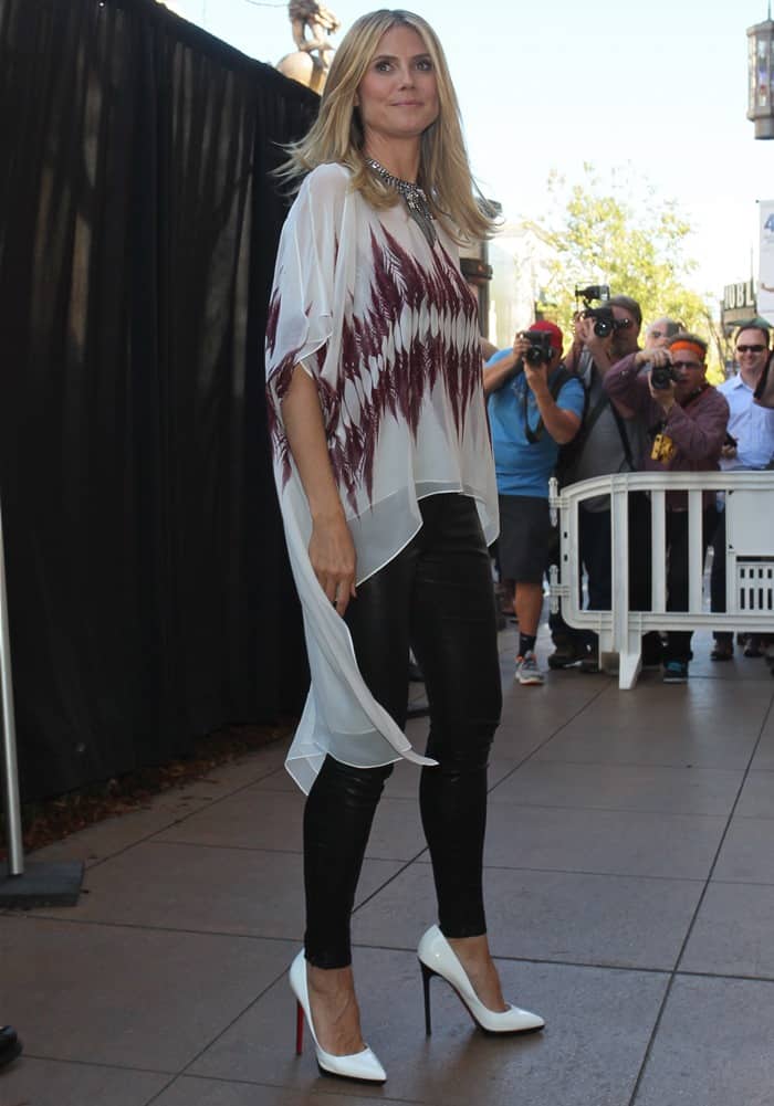 Heidi Klum showcased a relaxed yet stylish look, donning a breezy printed sheer blouse paired with leather trousers and pristine white heels