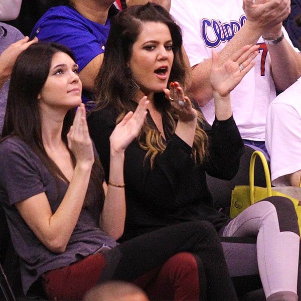 A spirited display of support: Kendall Jenner and Khloé Kardashian cheer on the LA Clippers, coordinated in striking paneled jeans, showcasing their unique style and unity at the basketball game