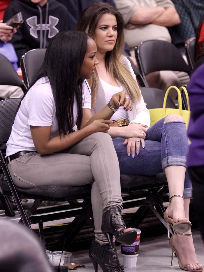 Khloe Kardashian talks with her best friend Malika Haqq at a basketball game