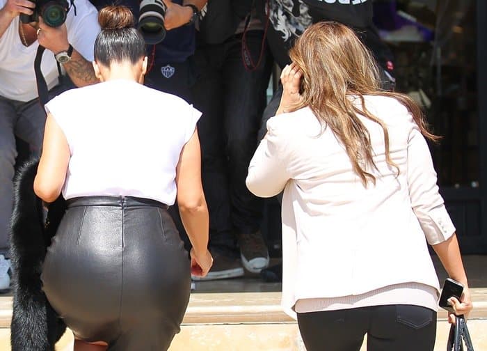 Kim Kardashian defines maternity elegance in Vince's skintight black leather pencil skirt, mastering the art of pregnancy style
