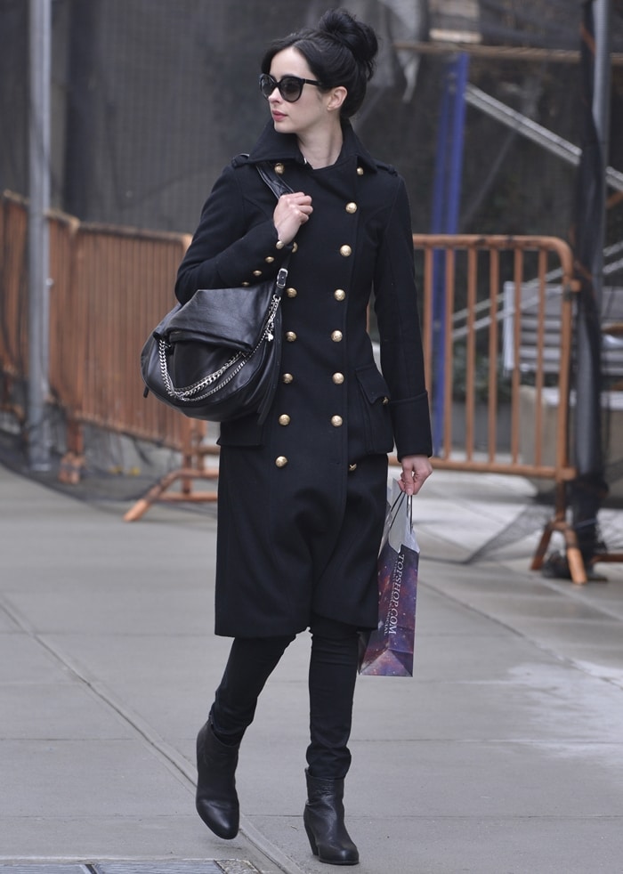 A closer look at Krysten Ritter's fashionable accessories: statement-making sunglasses, leather boots, and the luxurious Jimmy Choo 'Biker' handbag
