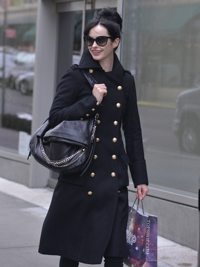 Krysten Ritter epitomizes chic elegance in a classic double-breasted trench coat, capturing the essence of old Hollywood glamour