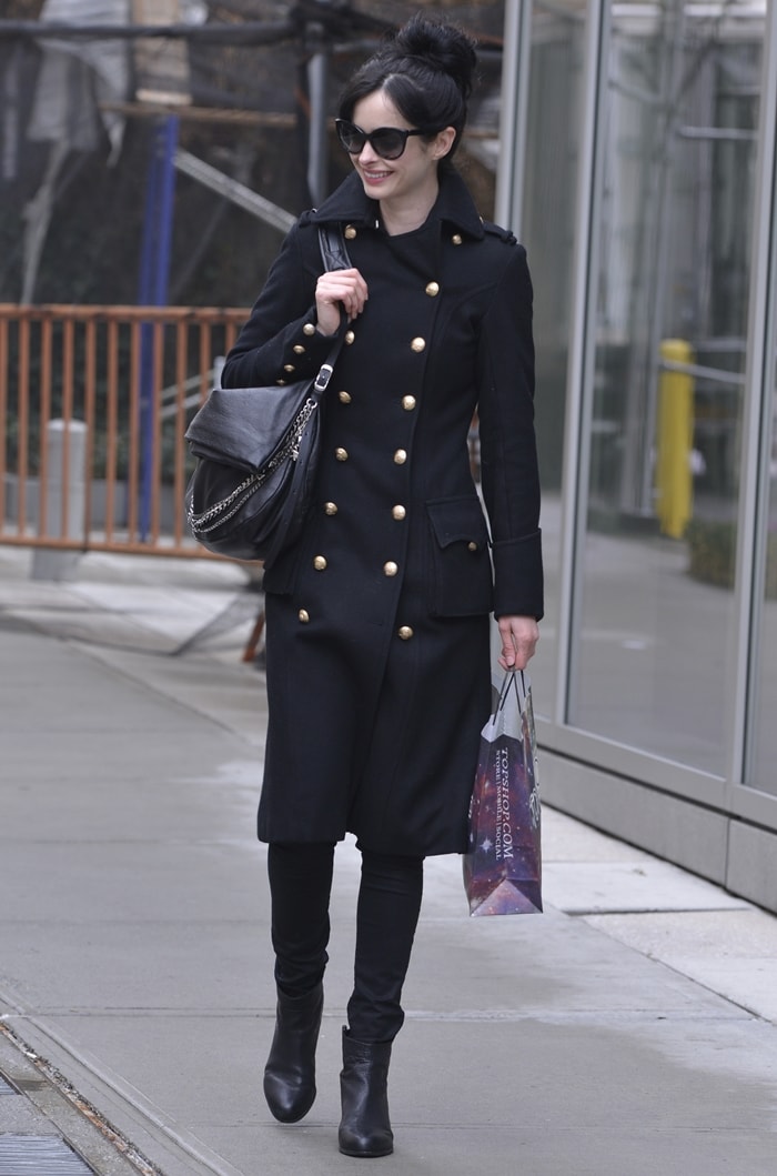 Krysten Ritter exudes sophistication with oversized sunglasses, sleek leather boots, and the iconic Jimmy Choo 'Biker' handbag