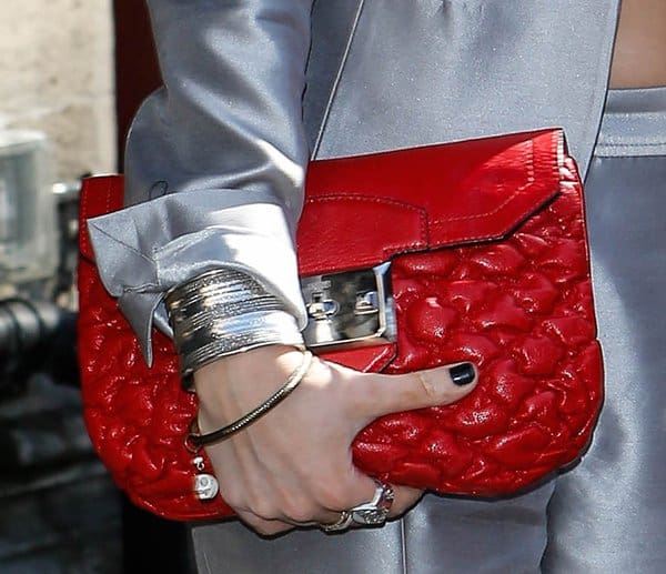At the TRIC Awards, Laura Whitmore's red quilted clutch becomes the centerpiece of her outfit, showcasing her flawless style