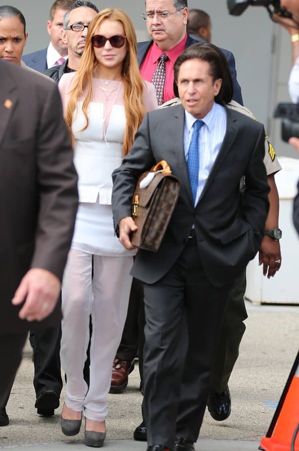 Lindsay Lohan stepping out of the courtroom, dressed in a sheer white peplum and trousers after her trial on charges from a car crash and probation violation, March 18, 2013, Los Angeles
