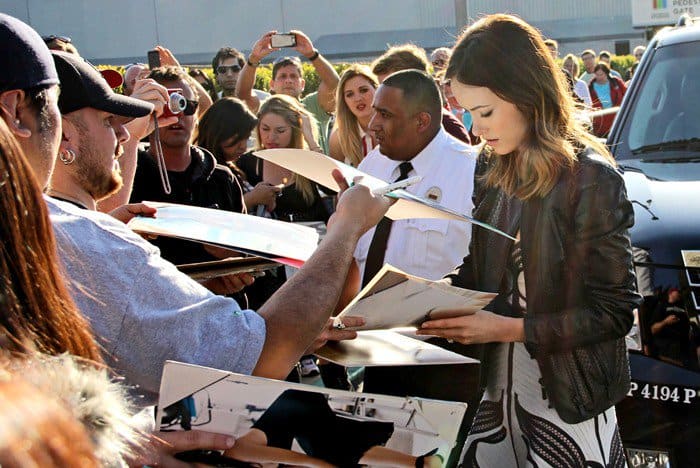 Olivia Wilde wears a black-and-white Herve Ledger dress as she signs autographs for fans