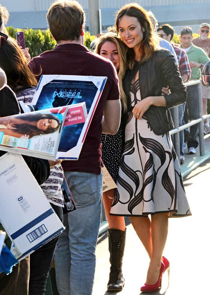 Olivia Wilde tops her Herve Ledger dress with a black leather jacket as she arrives at The Burbank Studios