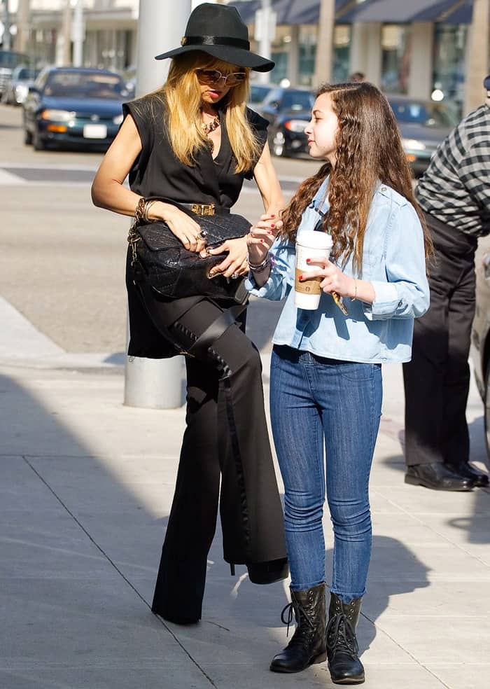 Rachel Zoe elevates classic tailoring with her towering height and signature flared pants in a sleek black suit