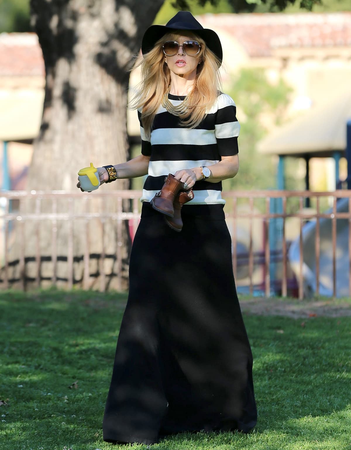 Rachel Zoe wears a black floor-length maxi skirt with a striped shirt and a wide-brimmed hat
