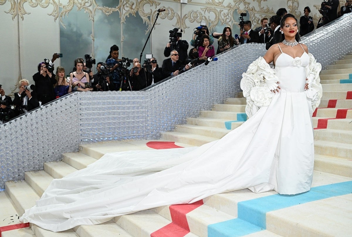 Rihanna made a stunning appearance in an exquisite white bridal gown at the Met Gala 2023, proudly flaunting her baby bump on fashion's grandest night