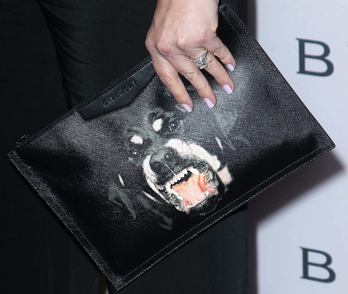 Drew Barrymore adds an edgy twist with a Rottweiler-printed Givenchy clutch, blending elegance with boldness
