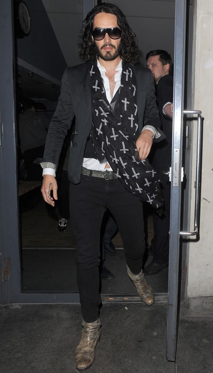 Russell Brand leaving the Soho Theatre wearing a crucifix-patterned scarf in London