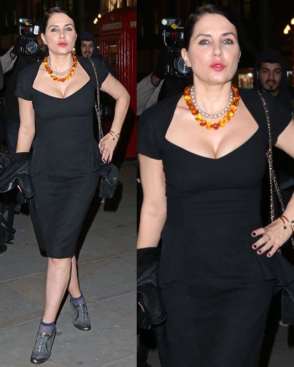 Sadie Frost exudes elegance in a classic black midi dress, accessorized with a bold amber statement necklace and grey heels for a sophisticated yet edgy look