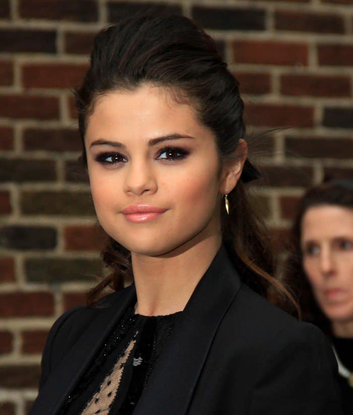 Selena Gomez finished her look with delicate gold rings and earrings, a polished ponytail, and glossy peach lips
