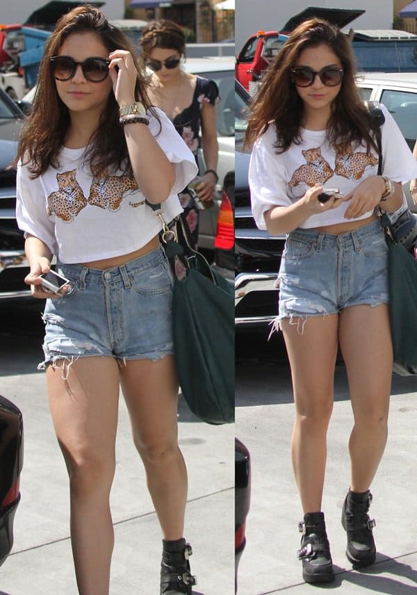 Stella Hudgens exudes spring break vibes in a chic white crop top, distressed denim shorts, and edgy rocker booties