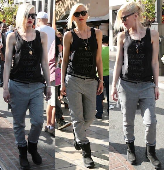 Gwen Stefani sported a casual yet edgy outfit consisting of a black tank top, printed loose trousers, and a pair of black boots