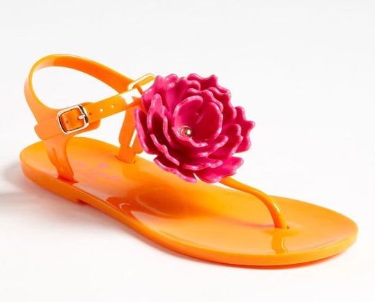 Perk up your sundress or your beach outfit with this bright orange thong and its bold pink flower!