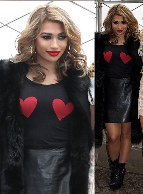 Vanessa White playfully mixed textures with a black fur coat and a vampy leather skirt, brightening her ensemble with a heart jumper and gorgeous bold red lipstick