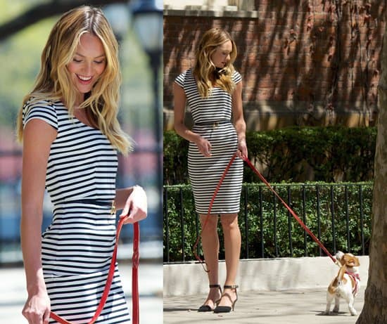 An adorable puppy accompanies Candice Swanepoel at a Victoria's Secret photoshoot, adding charm to the stylish setting