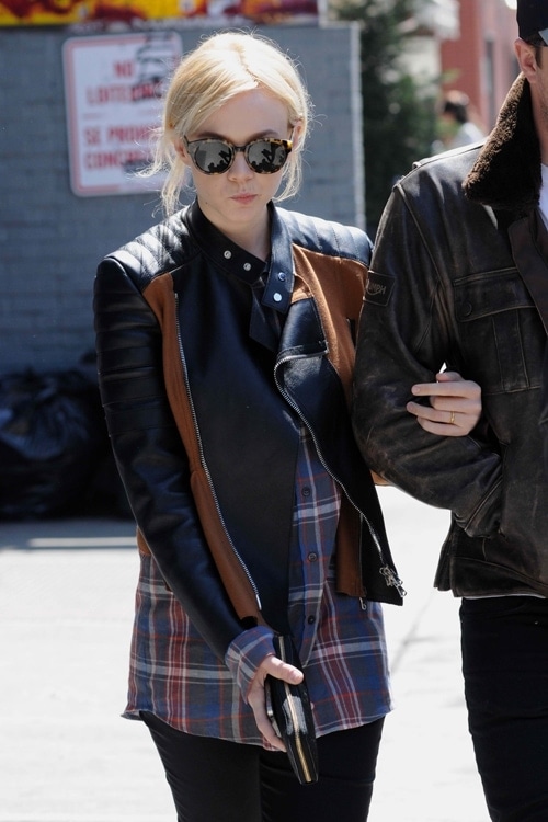 Carey Mulligan pairs a chic black leather jacket featuring brown trim with a plaid button-down top and black jeans
