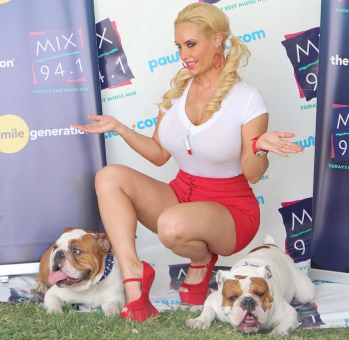 Coco Austin posing with her bulldogs Spartacus and Maximus at the Mix 94.1 Pet-a-Palooza event in Las Vegas