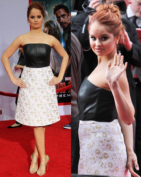 Debby Ryan stuns in a unique Osman ensemble featuring a structured black leather bustier and a white A-line skirt adorned with gold floral embroidery, paired with metallic gold strappy heels for a glamorous finish