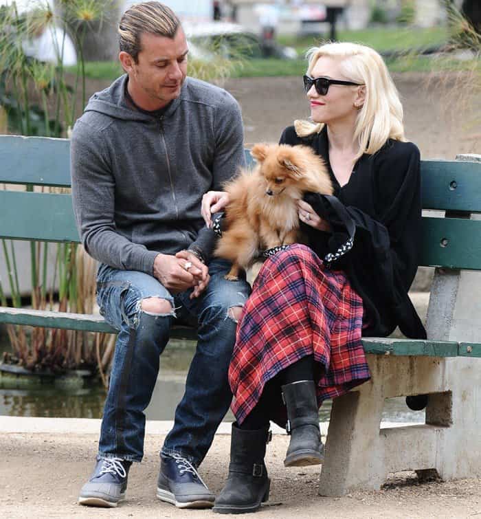 To style a long tartan skirt with a black pom-pom-detailed wrap, channel Gwen Stefani by pairing it with a sleek black sweater or top that highlights and complements the skirt's bold colors