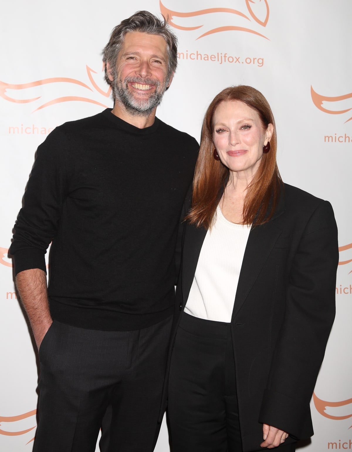 Julianne Moore, who is 5 feet 3 and a half inches tall (161.3 cm), appears notably shorter when compared to her husband, Bart Freundlich, whose height is 6 feet 2 and three-quarters inches (1.90 m), highlighting a significant height difference between the couple