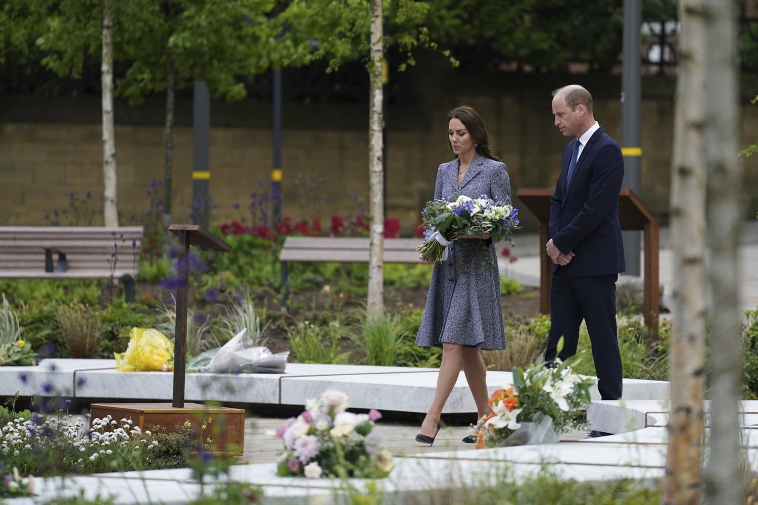 Britain's Kate the Duchess of Cambridge lays flowers as she and her husband Prince William attend the launch of the Glade of Light Memorial garden