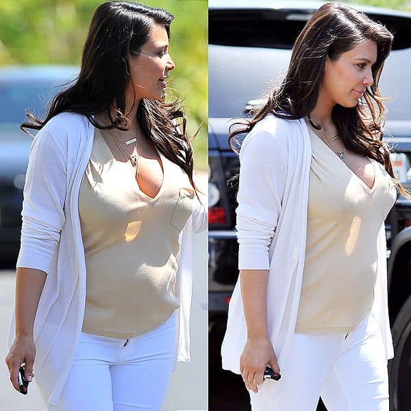Kim Kardashian showcases elegance in white maternity jeans, revealing a subtle baby bump with comfort and style