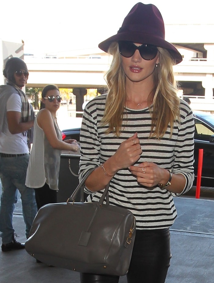 Rosie Huntington-Whiteley wears cat-eye sunglasses with a burgundy fedora