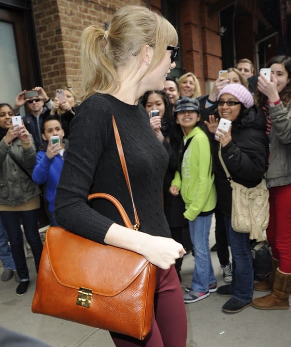 Taylor Swift leaving her Manhattan hotel, showcasing her classic style in a cashmere sweater, March 27, 2013